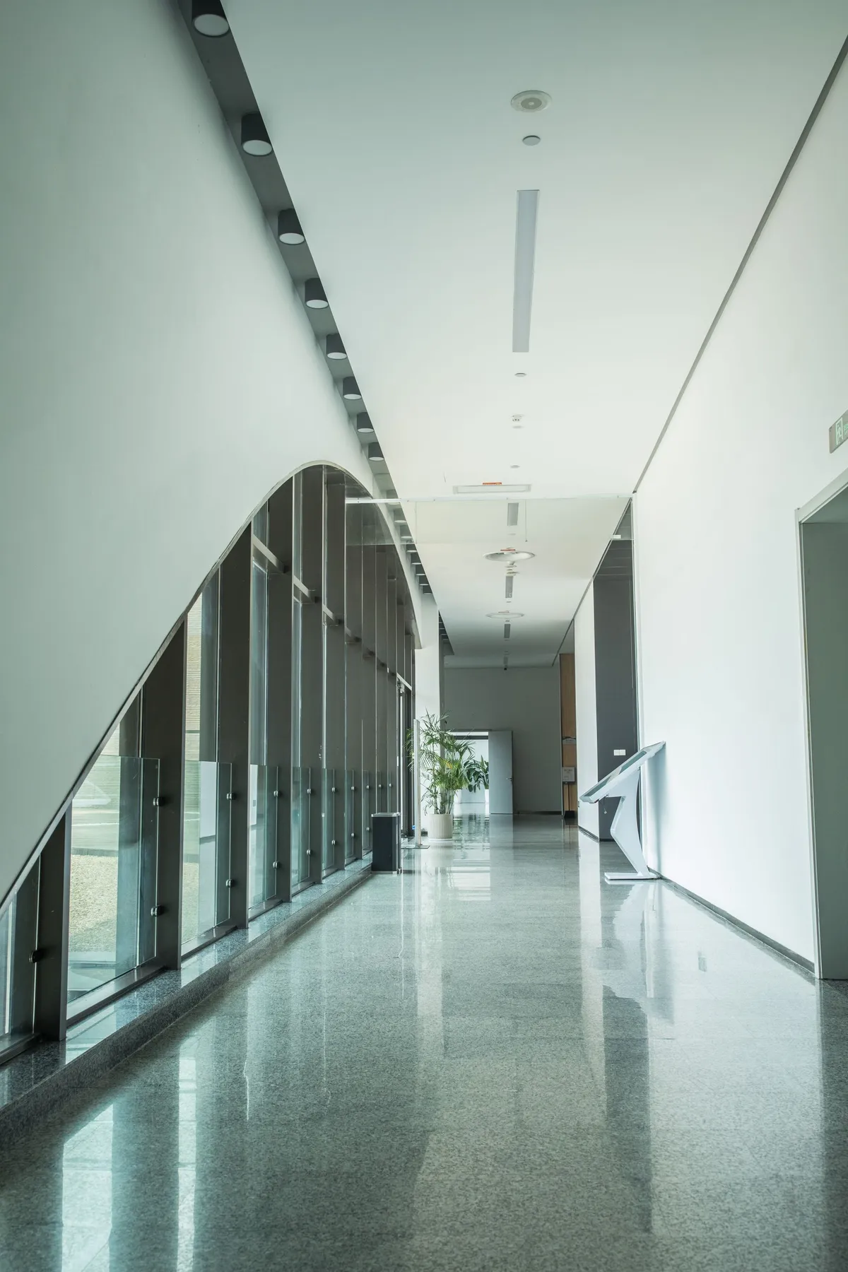 White wall and ceiling finishes in a bright commercial corridor with full-height glazing
