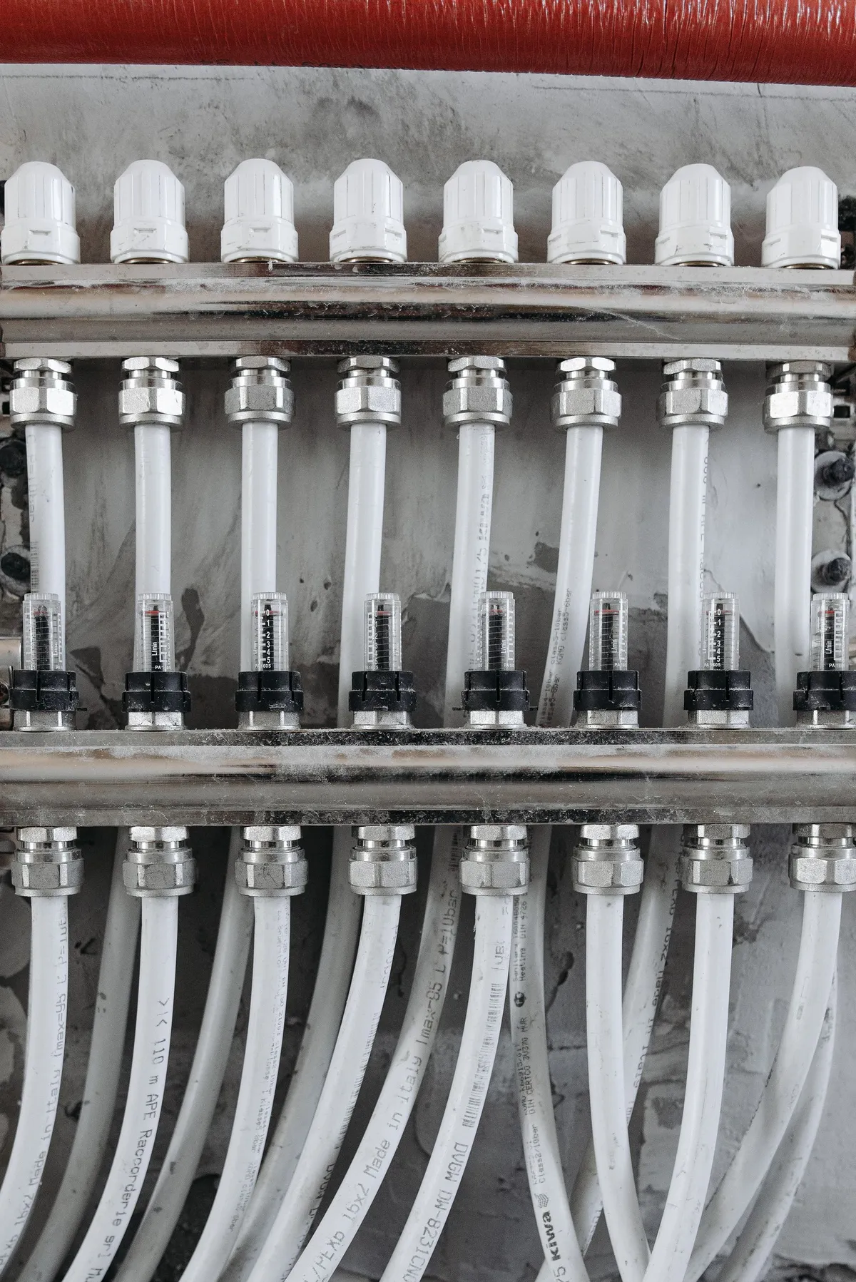 Plumbing distribution manifold with valves, flow meters, and connected pipework