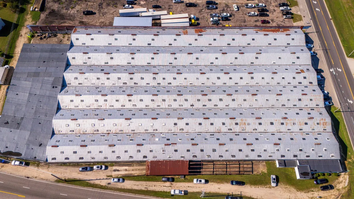 Aerial view of the metal roof and vents of an industrial warehouse